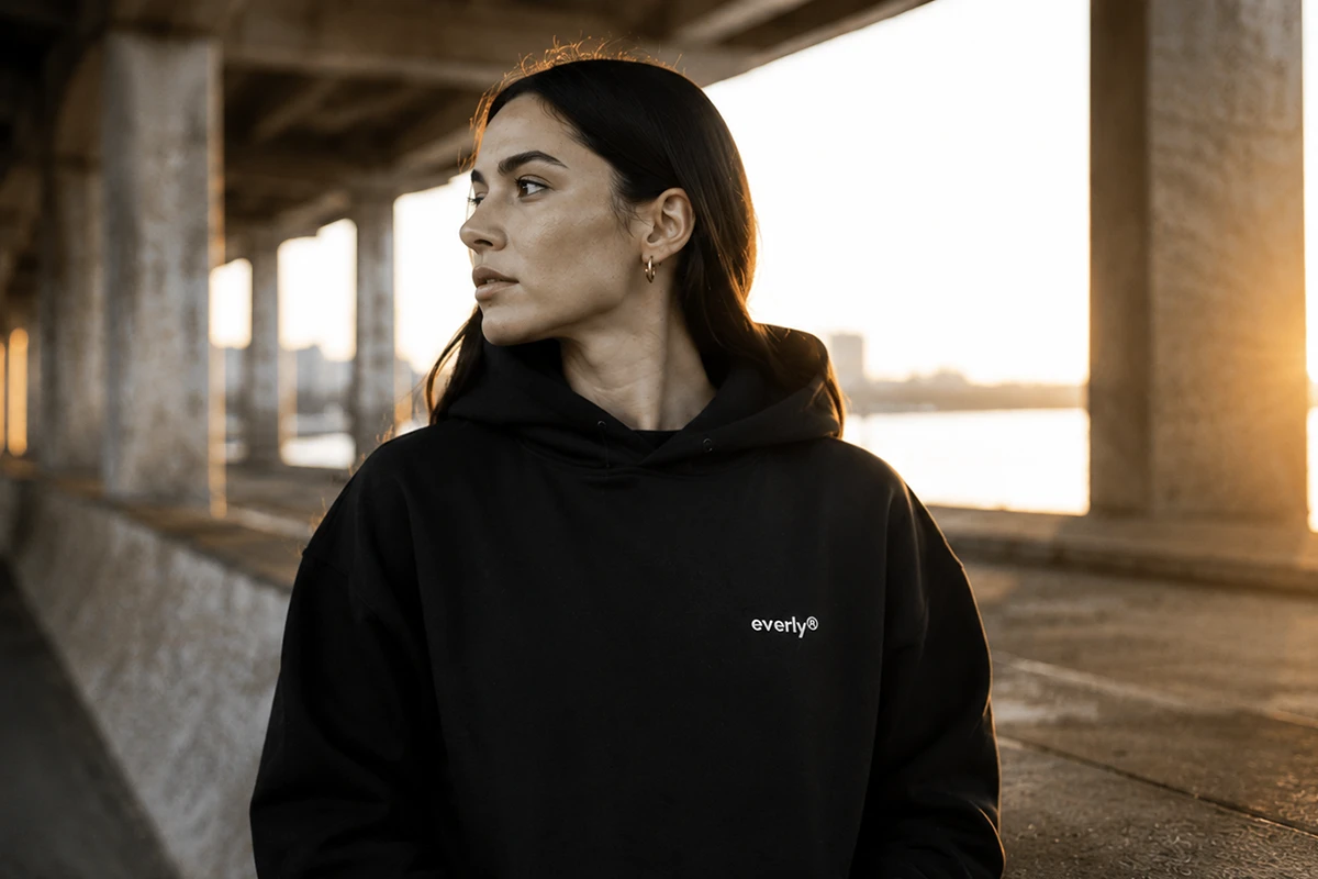 Frau im schwarzen Hoodie – Hoodies produzieren lassen mit Boldbrands